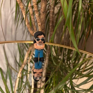 May include: A set of three ceramic mugs with a speckled, matte finish. The mugs are in shades of cream, light gray, and dark gray. Each mug has a simple, minimalist design, perfect for coffee or tea.