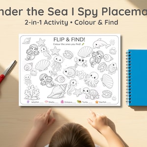 May include: An "Under the Sea I Spy Placemat" with a 2-in-1 activity. The placemat features a black and white illustration of sea creatures, including mermaids, jellyfish, and starfish. A blue notebook and red scissors are also visible.