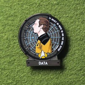 Könnte beinhalten: Runder Metallpin mit Data aus Star Trek: The Next Generation. Der Pin zeigt Data im Profil, in gelber und schwarzer Uniform. Der Text "TO BOLDLY GO WHERE NO ONE HAS GONE BEFORE" umrandet das Bild. Der Name "DATA" steht unten.