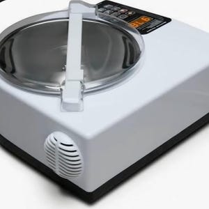 May include: A white appliance with a stainless steel bowl and a clear lid. The appliance has a control panel with buttons and a digital display. A white handle is attached to the lid. The appliance has a vent on the side.