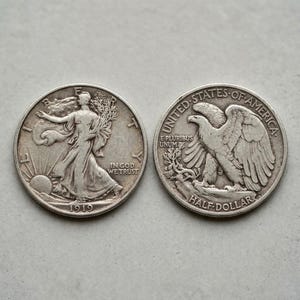 Könnte beinhalten: Zwei silberne Half-Dollar-Münzen. Eine Münze zeigt eine Frau, die auf die Sonne zugeht, mit dem Text "IN GOD WE TRUST" und dem Jahr 1919. Die andere Münze zeigt einen Adler mit dem Text "UNITED STATES OF AMERICA" und "HALF-DOLLAR".