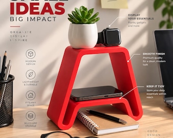 May include: A red U-shaped desk organizer with two tiers. The top tier holds a small green succulent in a white pot and a black smartwatch. The bottom tier holds a smartphone. Text on the image reads: SMALL IDEAS BIG IMPACT, ORGANIZE DISPLAY INSPIRE.