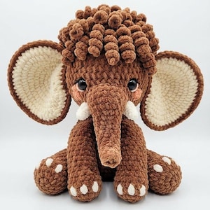 Studio shot of a brown chenille crochet mammoth toy facing forward against a plain white background.