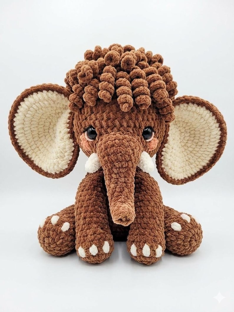 Studio shot of a brown chenille crochet mammoth toy facing forward against a plain white background.