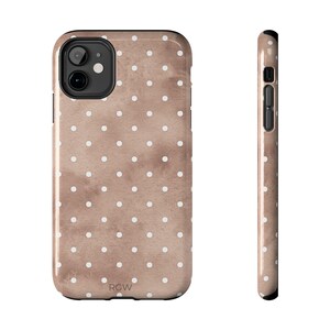 May include: A phone case with a brown watercolor background and white polka dots. The case has a black camera lens opening and a black border. The letters "RGW" are printed at the bottom of the case.