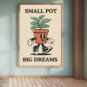 May include: A framed poster featuring a cartoon illustration of a walking orange flower pot with a plant inside. The poster has the text "SMALL POT" above the pot and "BIG DREAMS" below it. The pot is wearing black and white trainers.
