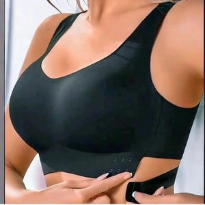Könnte beinhalten: Schwarzer Sport-BH mit rundem Ausschnitt und verstellbaren Trägern. Der BH hat einen Haken- und Ösenverschluss am Rücken und ein stützendes Design. Hergestellt aus glattem, nahtlosem Material.