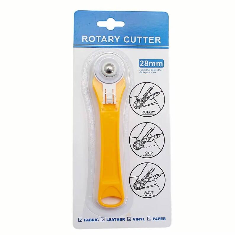 May include: A yellow rotary cutter with a 28mm blade, packaged on a white and blue card. The packaging includes illustrations demonstrating rotary, skip, and wave cutting techniques. The cutter is designed for fabric, leather, vinyl, and paper.