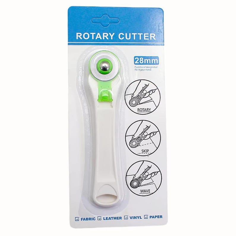 May include: A white and green rotary cutter with a 28mm blade, packaged on a blue and white card. The card features diagrams showing rotary, skip, and wave cutting styles. Suitable for fabric, leather, vinyl, and paper.
