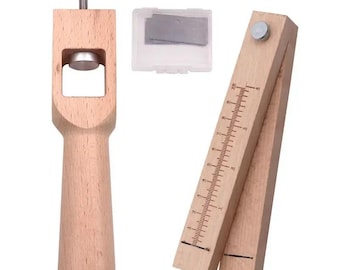 Puede incluir: Un juego de herramientas de madera clara para trabajar el cuero que incluye un punzón vertical con perilla de ajuste negra, una caja de plástico transparente con cuchillas metálicas y un cortador de correas con regla graduada en cm.