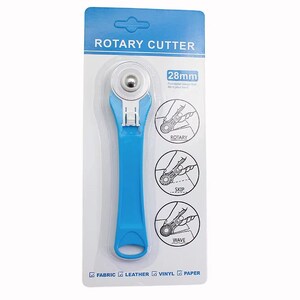 May include: A blue rotary cutter with a 28mm blade, packaged on a white and blue card. The package includes diagrams showing rotary, skip, and wave cutting styles. The cutter is designed for fabric, leather, vinyl, and paper.