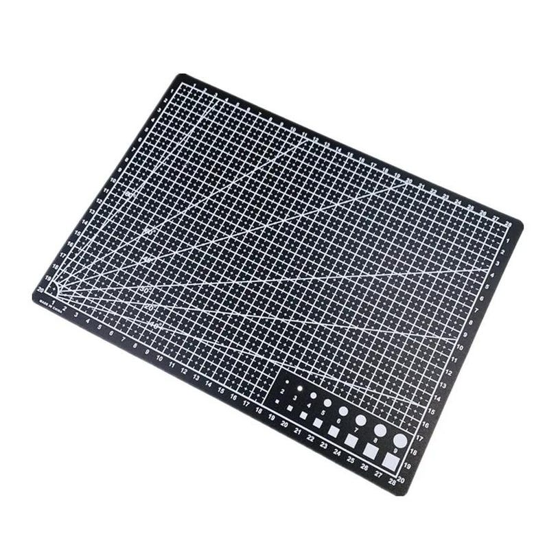 K&ouml;nnte beinhalten: Eine schwarze Schneidematte mit wei&szlig;en Gitterlinien, Winkelmarkierungen und Ma&szlig;angaben. Die Matte enth&auml;lt ein Lineal entlang der Kanten und verschiedene Formen und Gr&ouml;&szlig;en zum Schneiden. Die Ma&szlig;e sind in Zentimetern.