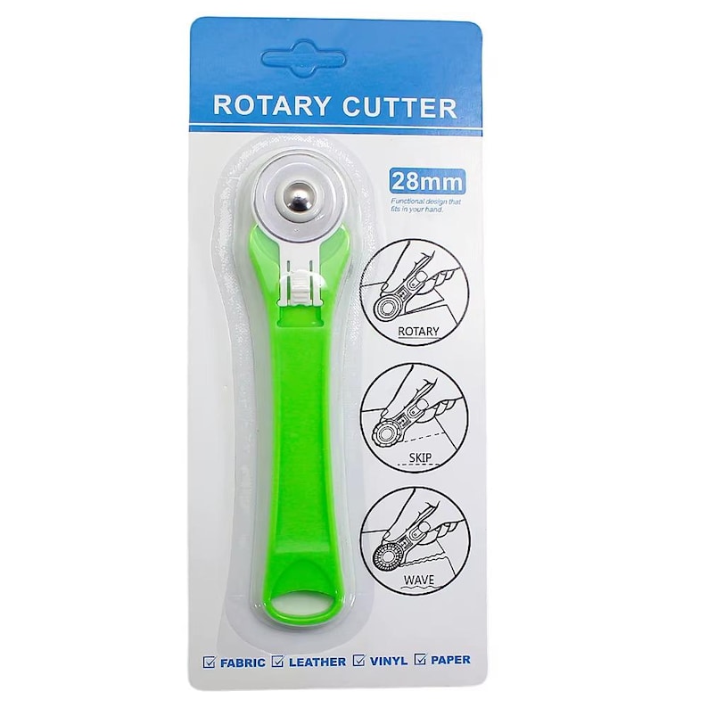 May include: A green rotary cutter with a 28mm blade, designed for fabric, leather, vinyl, and paper. The packaging includes diagrams illustrating rotary, skip, and wave cutting techniques. The text "ROTARY CUTTER" is at the top.