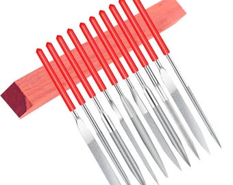 Puede incluir: Un juego de diez limas de aguja de metal con mangos de plástico rojo brillante, dispuestas en una fila diagonal. Cada lima presenta una forma distinta, incluyendo perfiles planos, redondos y triangulares, con hojas de acero de color plateado.
