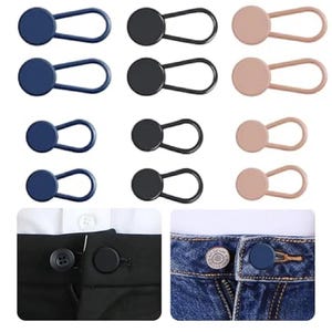 Könnte beinhalten: Eine Sammlung von Knopfverlängerungen in Marineblau, Schwarz und Beige. Die Verlängerungen haben an einem Ende einen Knopf und am anderen eine Schlaufe. Das Bild zeigt die Verwendung der Verlängerungen an einer schwarzen Hose und einer Jeans.
