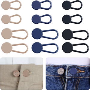 May include: A collection of button extenders in various colors, including beige, navy blue, and black. The extenders feature a circular button with a looped elastic band. The image also shows the extenders in use on pants.