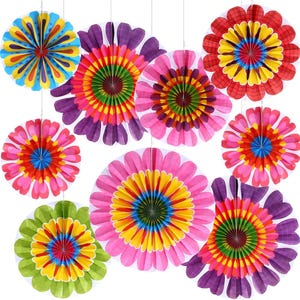 May include: A collection of colorful paper flower decorations in various sizes and designs. The flowers feature bright colors like pink, yellow, green, and purple, with intricate folded patterns. Each flower is suspended by a thin string, creating a festive display.