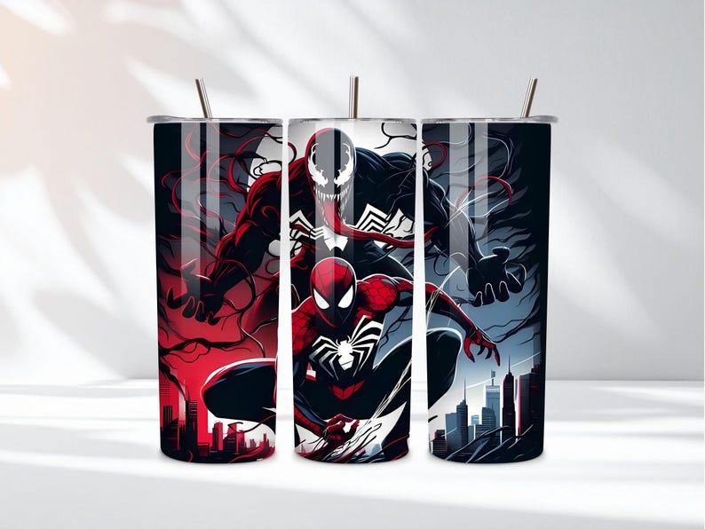 May include: Three stainless steel tumblers with a superhero theme. The tumblers feature illustrations of Spider-Man, Venom, and Carnage against a cityscape backdrop. The color scheme includes red, black, and blue, with silver straws.