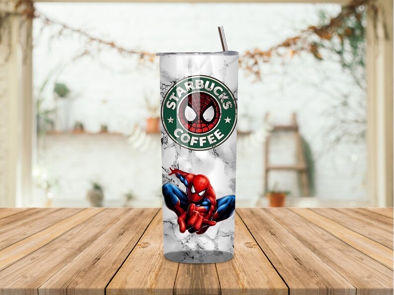 May include: A stainless steel tumbler with a marble effect design, featuring the Starbucks Coffee logo with a Spider-Man graphic. The tumbler has a silver straw and is on a wooden table.