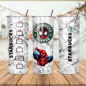 May include: Three Starbucks tumblers with a marble effect. One tumbler features the Starbucks logo with a Spider-Man graphic. The other two tumblers have the Starbucks logo and a section for drink customisation. Each tumbler has a silver straw.