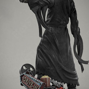 May include: A black figure in a hooded robe, holding a knife, stands on a base with movie-themed props. The base includes a "DRIVE-IN" sign, film reel, popcorn, and a red cup. The figure's mask is visible.