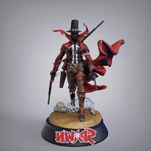 May include: A detailed figurine of a character in a red coat and hat, holding two guns and a rifle. The figure stands on a base with the word "Spawn" in red and white. The character has a black mask and a white chest design.