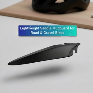 K&ouml;nnte beinhalten: Ein schwarzer, leichter Sattelkotfl&uuml;gel f&uuml;r Rennr&auml;der und Gravelbikes. Das Bild zeigt den Kotfl&uuml;gel mit dem Text "Lightweight Saddle Mudguard for Road & Gravel Bikes". Ein schwarzer Helm und Werkzeuge sind im Hintergrund.