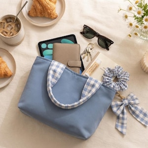 Handmade blue gingham mini bow tote sitting on a table, showing the finished bag made from the beginner-friendly PDF sewing pattern.