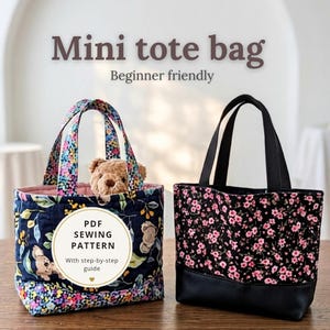 Pode incluir: Duas mini bolsas tote com alças de tecido. A bolsa da esquerda apresenta um padrão floral azul-escuro com ilustrações de coalas e interior rosa. A da direita tem uma estampa floral preta com base preta. Texto: STUDIO PETITE MINI TOTE.