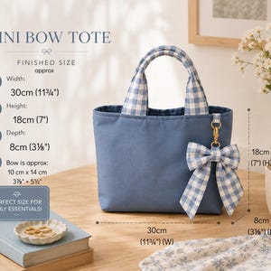 A blue mini bow tote bag with blue and white gingham handles and a matching gingham bow charm. The bag measures 30 cm wide, 18 cm high, and 8 cm deep. The bow measures approximately 10 cm by 14 cm. Text reads MINI BOW TOTE.