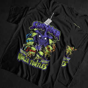 May include: Black t-shirt featuring a graphic of the Teenage Mutant Ninja Turtles and Shredder. The design includes the words "Shredder" and "Teenage Mutant Ninja Turtles" in a green and purple color scheme. A tag reads "Large".