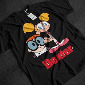 May include: Black t-shirt featuring a cartoon graphic of Dexter and Dee Dee from the animated series Dexter's Laboratory. The word "Dexter" is printed in red. The shirt has a tag that says "LARGE".
