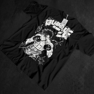 May include: Black t-shirt featuring a white and black illustration of a boxer in a fighting stance. The graphic includes Japanese text and a tag that reads "LARGE". The design is a bold, graphic style.