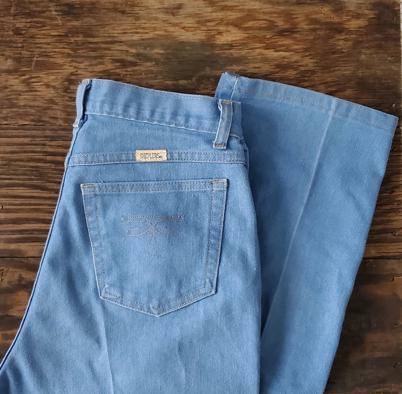 Op de afbeelding: Lichtblauwe spijkerbroek met een uitlopende pijp. De jeans heeft een klassiek ontwerp met vijf zakken, een knoop- en ritssluiting en een klein label op de achterzak. De jeans is gemaakt van een duurzame denim stof.
