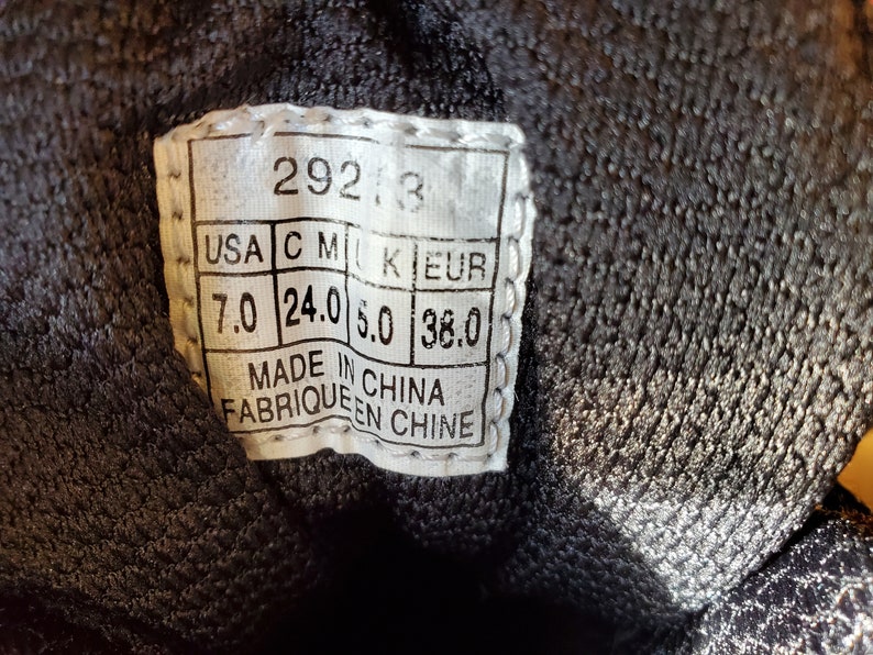 Peut inclure: Une &eacute;tiquette blanche avec du texte noir indiquant les pointures en US, CM, UK et EUR. L'&eacute;tiquette indique "292, 3", "USA C M UK EUR", "7.0 24.0 5.0 38.0", "MADE IN CHINA", "FABRIQUE EN CHINE".