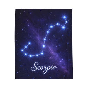 Peut inclure: Une couverture bleu foncé représentant la constellation du Scorpion en blanc brillant, avec le mot "Scorpio" en écriture cursive. Le fond représente un ciel étoilé avec une nébuleuse violette.