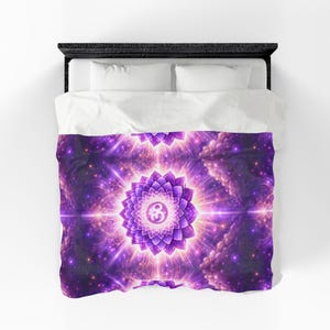May include: A purple and pink duvet cover featuring a mandala design with an Om symbol at the center. The design has a floral pattern with radiating light and a starry background. The bedding is on a black bed frame with white pillows.