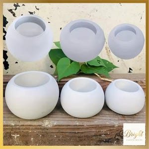 Può includere: Una collezione di stampi per candele sferici bianchi di varie dimensioni. Gli stampi hanno una forma liscia e arrotondata con un'apertura circolare nella parte superiore. L'immagine include un logo per Bright Candle Molds.