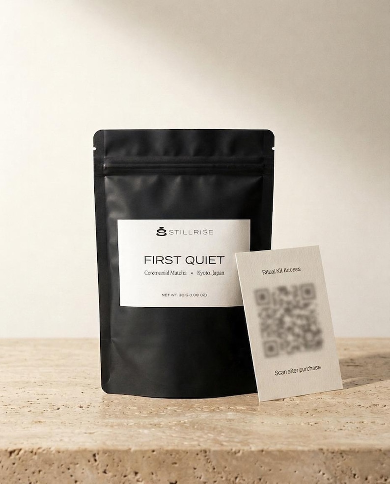 Pode incluir: Uma embalagem preta de matcha cerimonial "FIRST QUIET" de Kyoto, Jap&atilde;o, com um r&oacute;tulo branco e o logotipo "STILLRISE". Um pequeno cart&atilde;o com um c&oacute;digo QR e o texto "Ritual Kit Access" est&aacute; ao lado da embalagem. O peso l&iacute;quido &eacute; de 30g.