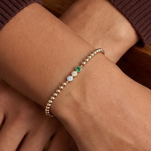 May include: A white ceramic mug with a black handle and the text "But First, Coffee" in a handwritten style. The mug is on a white surface. The mug is approximately 4 inches tall.