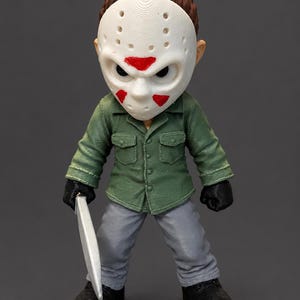 May include: A stylized figurine featuring a white hockey mask with red triangular markings, brown hair, a green button-down shirt, gray pants, black gloves, and black boots. The figure holds a silver-colored blade in its right hand.