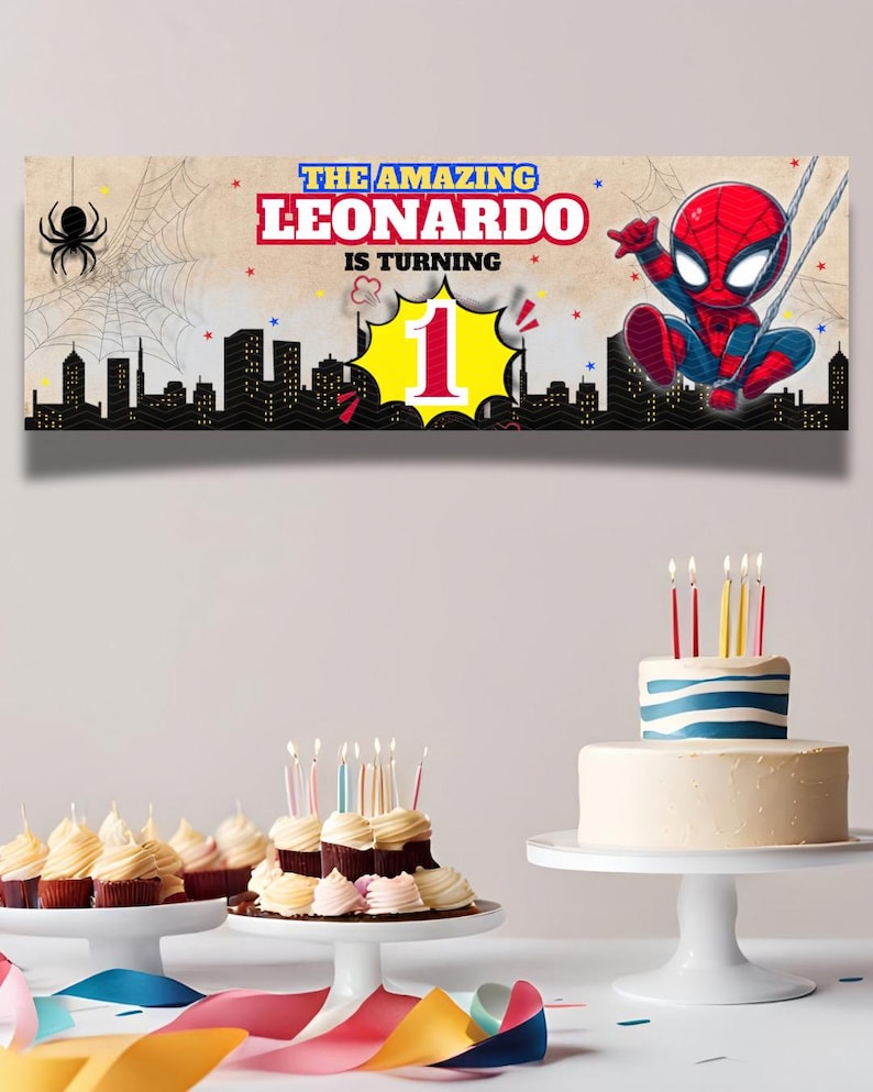 May include: A birthday banner featuring Spider-Man with the text "THE AMAZING LEONARDO IS TURNING 1". The banner has a cityscape silhouette and a spider web design. Cupcakes and a cake with candles are also visible.
