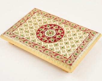 May include: A rectangular serving tray with a gold-toned border and a central red circular medallion. The surface features a cream-colored lattice pattern accented with small green gems and intricate red and gold floral motifs.