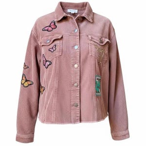 May include: Dusty rose corduroy jacket with butterfly patches. The jacket has a button-up front, two chest pockets, and a frayed hem. The butterfly patches are in various colors, including pink, yellow, and orange. The jacket has a classic, casual style.