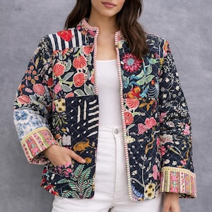 Può includere: Giacca trapuntata con un vivace motivo floreale e geometrico in blu navy, rosso, rosa e verde. La giacca presenta un collo alto, un bordo a contrasto e un design patchwork. Le maniche hanno polsini fantasia e la giacca ha tasche.