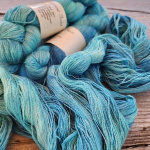 May include: A skein of teal and blue hand-dyed yarn with the label "Hand Twist Yarn" and "Herbed"