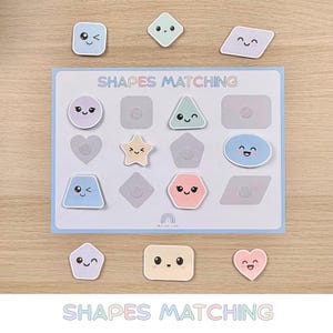 Puede incluir: Un juego educativo Shapes Matching con un borde azul claro. El juego presenta varias formas coloridas con caras sonrientes, incluyendo cuadrados, triángulos, corazones y estrellas. El texto "SHAPES MATCHING" se muestra en el tablero.