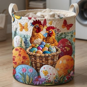 May include: A round laundry hamper with a colorful Easter theme. The design features two roosters, a basket of decorated eggs, and several large, decorated Easter eggs. Butterflies and flowers are also present. The hamper has cream-colored handles and a cream-colored interior.
