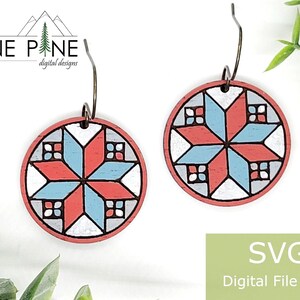 Pode incluir: Um par de brincos redondos de madeira com um design de estrela geométrica em vermelho, branco e azul claro. Os brincos têm um gancho de metal escuro e são da Lone Pine Digital Designs. A imagem também inclui o texto "SVG Digital File Only".