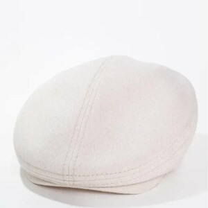 May include: Off-white, flat cap made of a textured fabric. The hat has a rounded crown and a small, stiff brim. The cap features a seam running down the center and is a classic style.